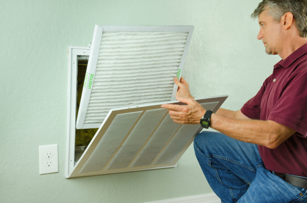 man checking the filters on home vents
