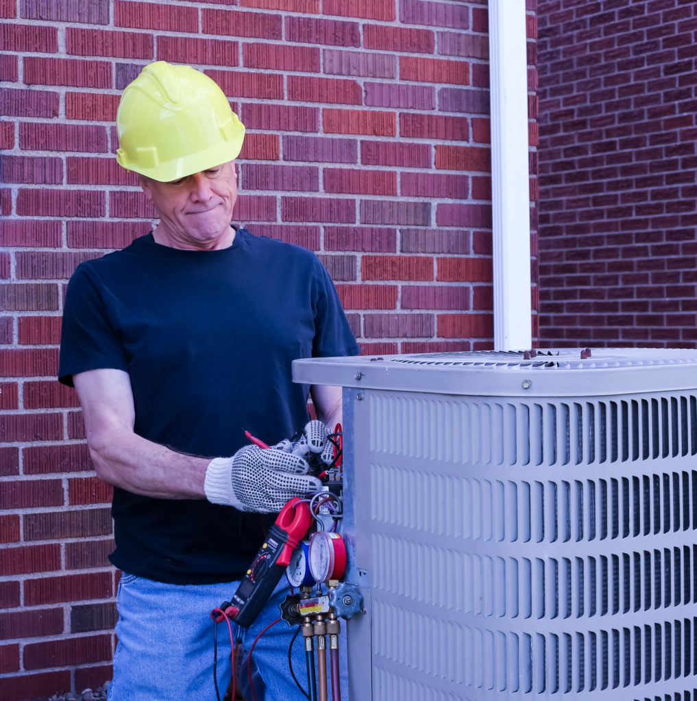 HVAC tech checking a new HVAC unit after an AC covnersion