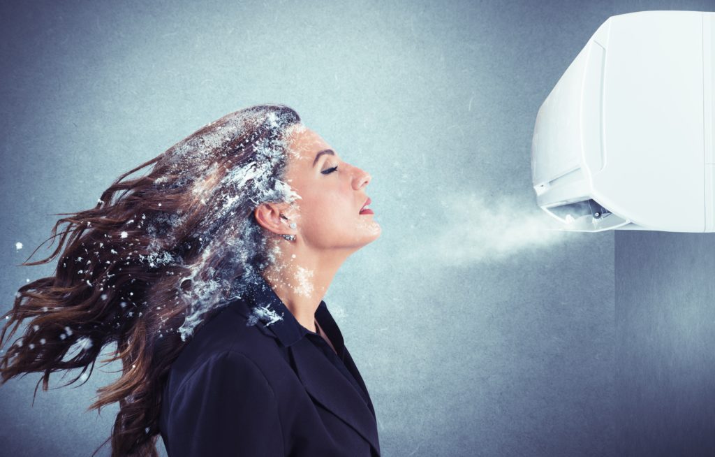 Frozen girl under a powerful air conditioner