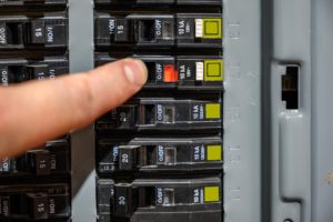 A finger adjusting the Home Electricity breaker box