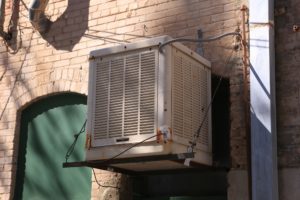 an older swamp cooler sits on the side of a building