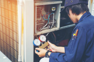 A technician performing air conditioning maintenance on a residential unit