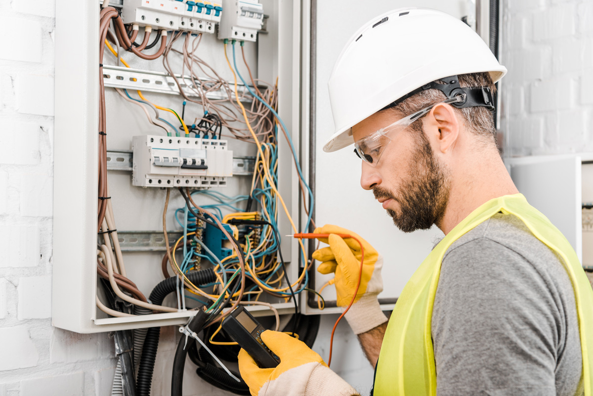 An electrician making a repair to an electrical box in El Paso.