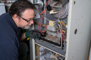 An HVAC contractor performing maintenance on an HVAC system in El Paso.