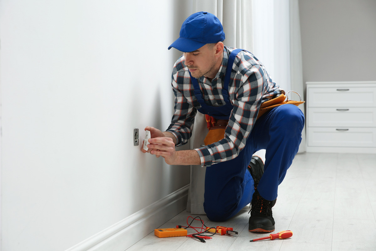 An electrical contractor in El Paso performing work on an electrical outlet.